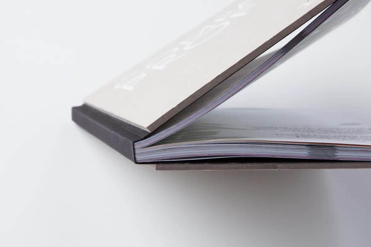 Encuadernación de un libro con tapas de cartón gris de Omán Impresores