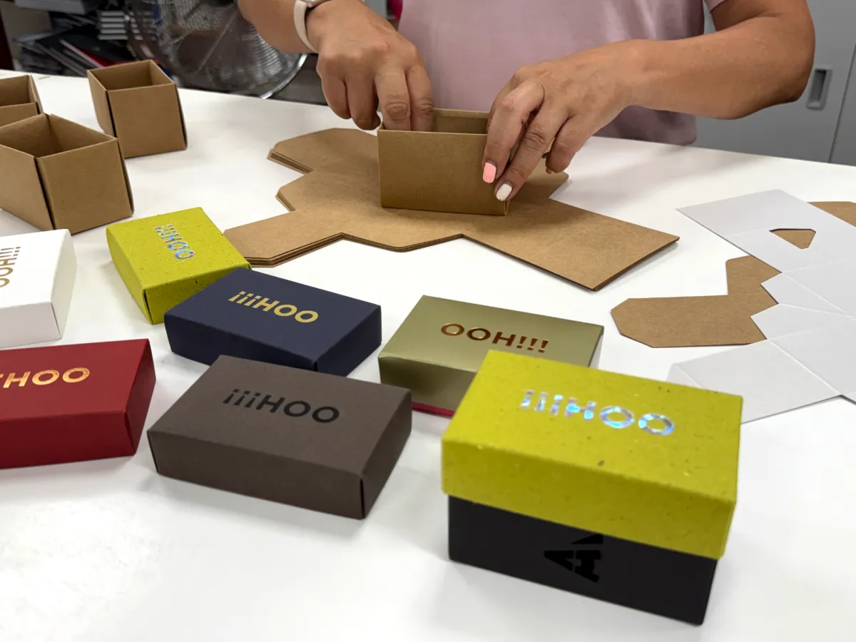 Montaje manual de cajas de colores en el taller de Omán Impresores